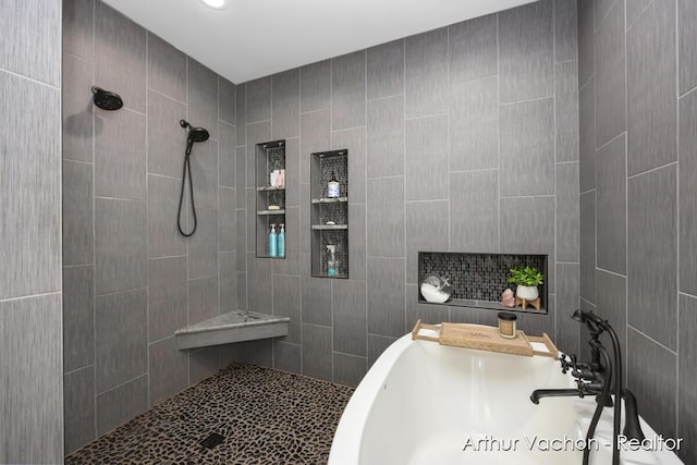 bathroom with tiled shower and a sink