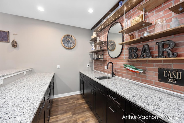 bar with dark wood finished floors, recessed lighting, backsplash, a sink, and baseboards