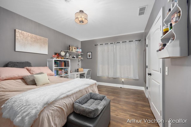 bedroom with visible vents, dark wood finished floors, and baseboards