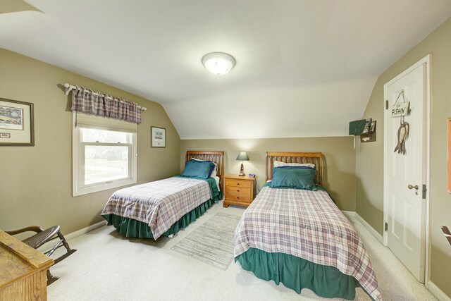 bedroom with baseboards, vaulted ceiling, and carpet flooring