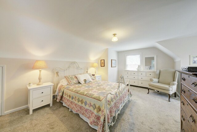 bedroom featuring light carpet and vaulted ceiling