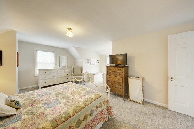 carpeted bedroom with lofted ceiling and baseboards