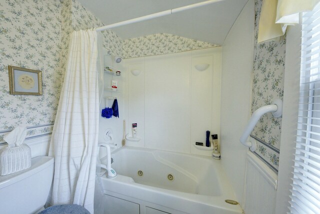 full bath with toilet, wallpapered walls, and a combined bath / shower with jetted tub