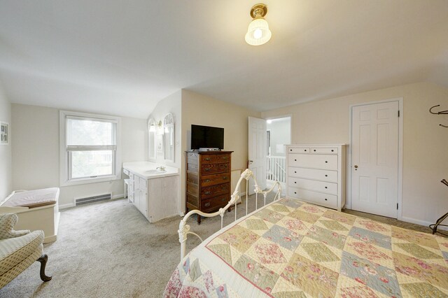 bedroom with lofted ceiling, light colored carpet, a sink, visible vents, and baseboards