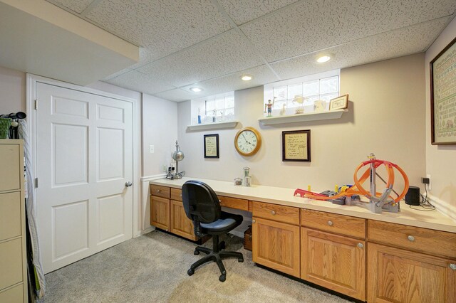 office with recessed lighting, a drop ceiling, built in desk, and light colored carpet