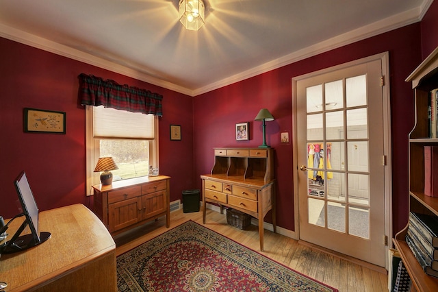 office space featuring crown molding, light wood-style flooring, and baseboards