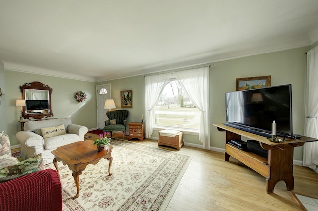 living room with light wood finished floors, baseboards, and crown molding