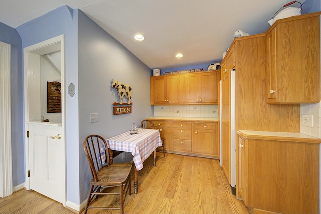 kitchen featuring recessed lighting, backsplash, light countertops, and light wood-style flooring