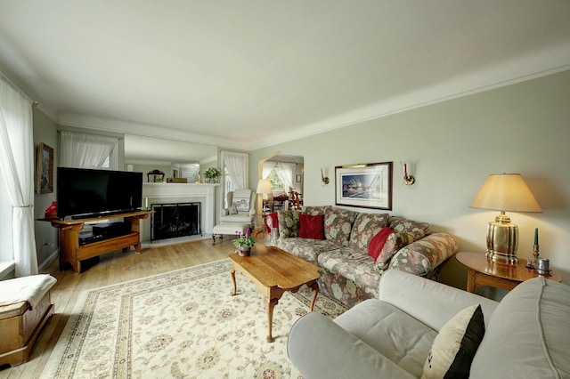 living area with plenty of natural light, hardwood / wood-style flooring, and crown molding