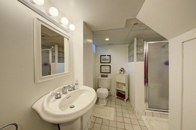 bathroom featuring visible vents, toilet, a sink, a shower stall, and tile patterned flooring