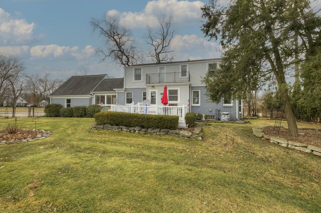 back of property with brick siding, a yard, and fence