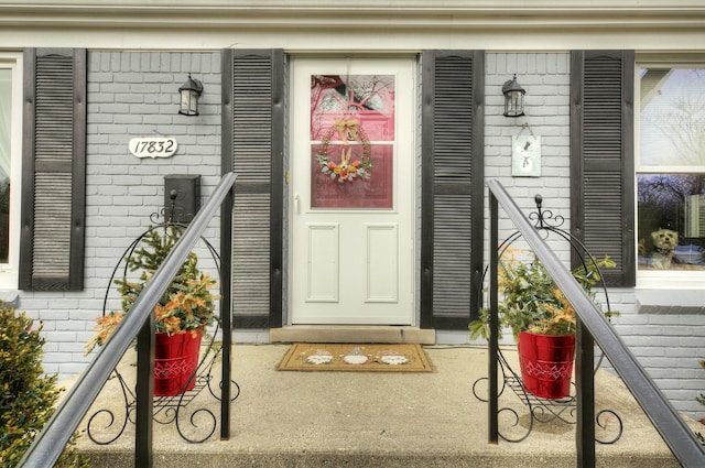 doorway to property featuring brick siding