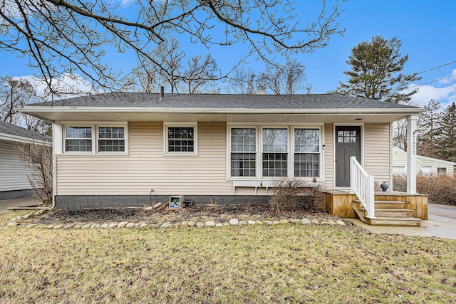 view of front of house featuring roof with shingles and a front yard