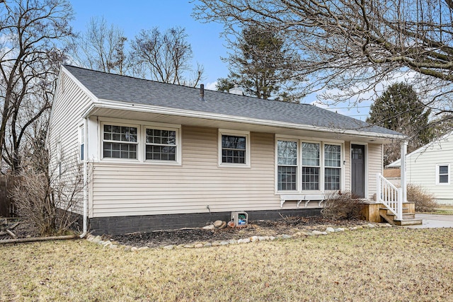 view of front of home featuring a shingled roof and a front yard