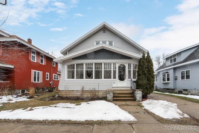 view of front of home with entry steps and a sunroom