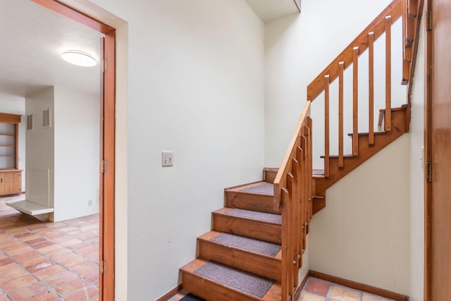 staircase featuring visible vents and baseboards