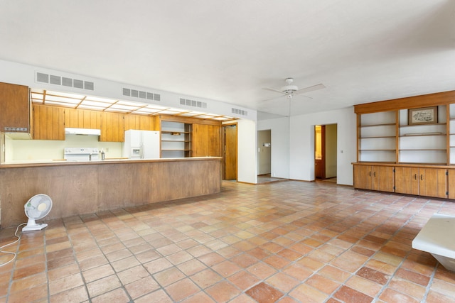 kitchen featuring under cabinet range hood, visible vents, white refrigerator with ice dispenser, and range