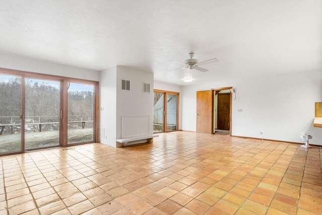 empty room with visible vents, baseboards, and ceiling fan