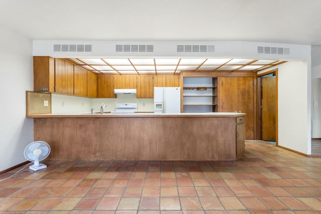 kitchen featuring under cabinet range hood, visible vents, and white appliances