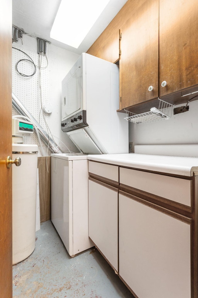 laundry area with stacked washer / drying machine and cabinet space