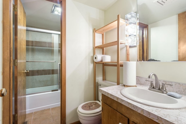 bathroom with visible vents, toilet, tile patterned flooring, bath / shower combo with glass door, and vanity