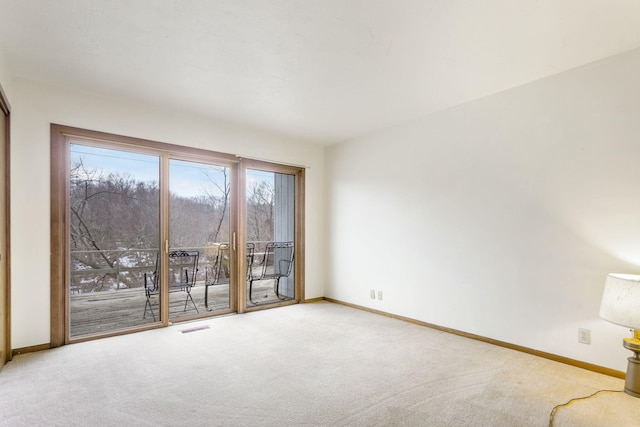 carpeted spare room with visible vents and baseboards