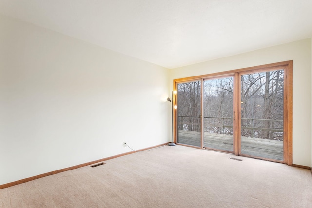 empty room with visible vents, baseboards, and carpet floors