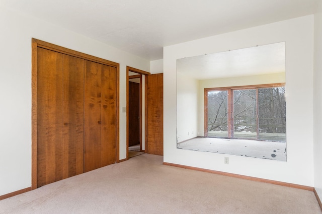 unfurnished bedroom featuring baseboards, a closet, and carpet floors