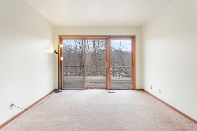 carpeted spare room featuring visible vents and baseboards