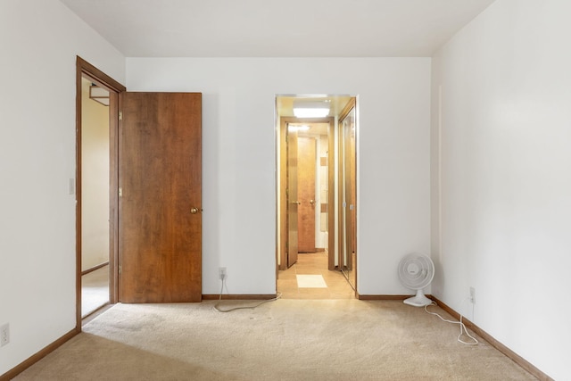 unfurnished bedroom with light colored carpet and baseboards