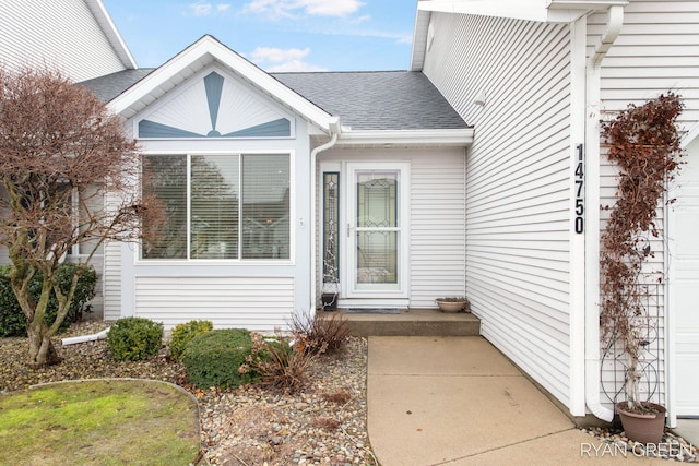 doorway to property featuring a shingled roof