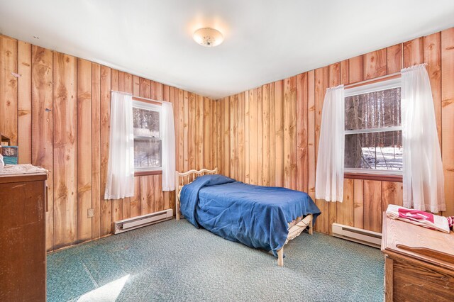 bedroom featuring wooden walls and a baseboard radiator