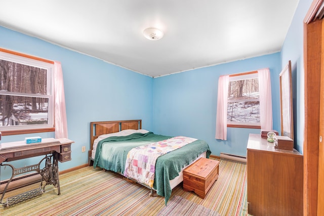 carpeted bedroom with a baseboard heating unit and baseboards