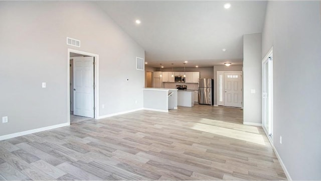 unfurnished living room featuring high vaulted ceiling, baseboards, visible vents, and light wood finished floors