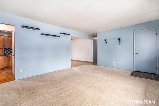 carpeted spare room featuring baseboards