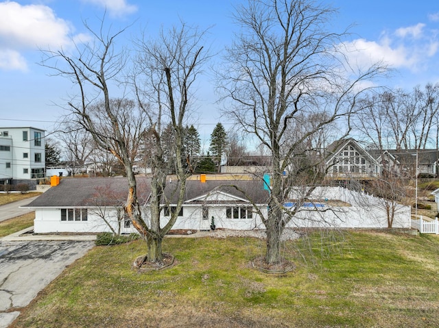 view of front of home featuring a front yard, driveway, and fence