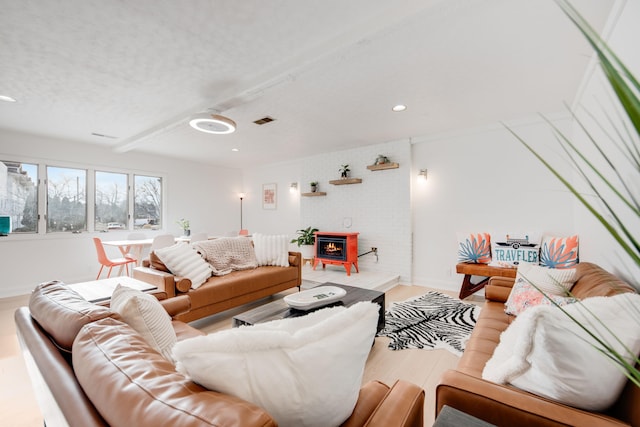 living room with a textured ceiling, recessed lighting, wood finished floors, visible vents, and baseboards