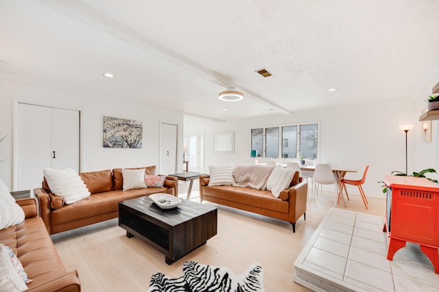 living room with light wood-type flooring, recessed lighting, visible vents, and beamed ceiling