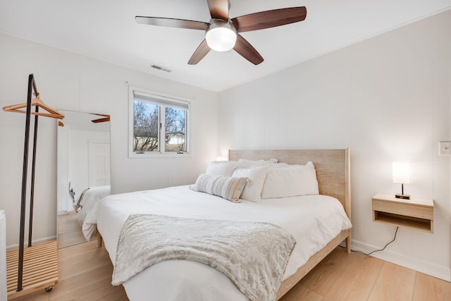 bedroom with light wood-type flooring, visible vents, and a ceiling fan