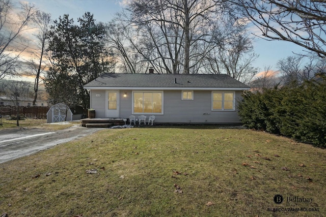 ranch-style home with a yard, a shed, an outdoor structure, and driveway