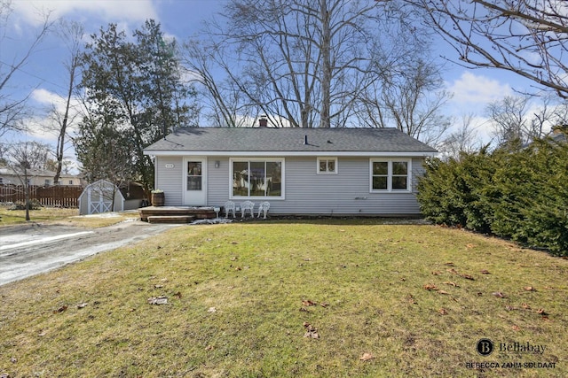 view of front of home with an outbuilding, fence, a shed, a front lawn, and a chimney