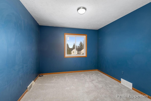 unfurnished room featuring carpet floors, visible vents, and baseboards