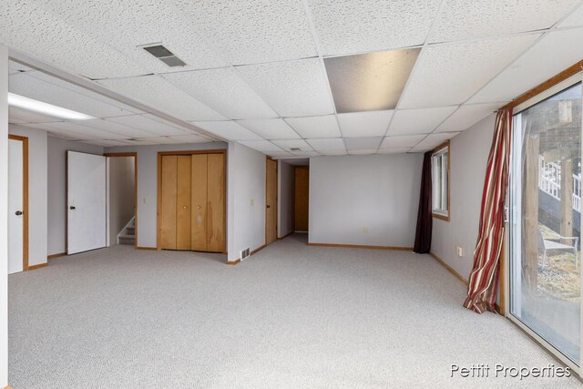 spare room featuring light carpet, visible vents, stairway, and baseboards