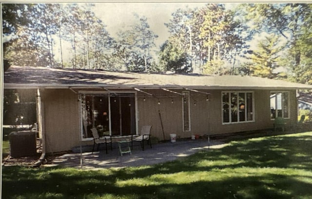 rear view of property with a patio area, a lawn, and stucco siding