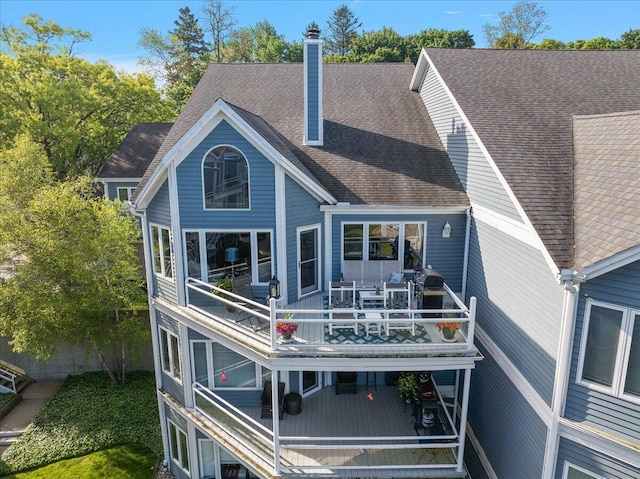 4144 Ridge Rd Unit 16, Stevensville, MI 49127 - back of house featuring a chimney, outdoor dining area, and a shingled roof