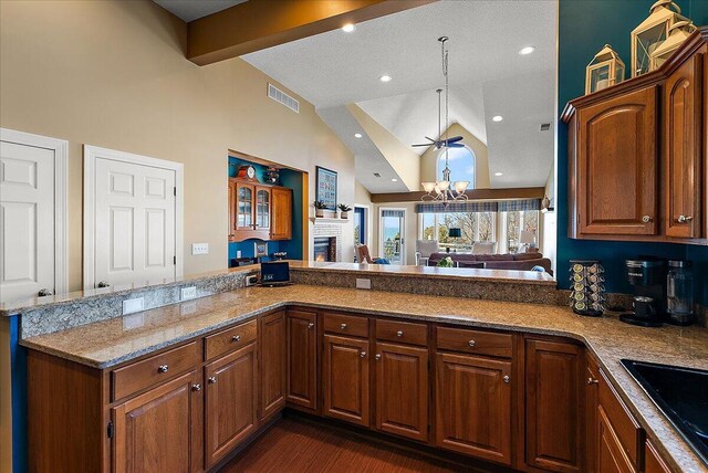 4144 Ridge Rd Unit 16, Stevensville, MI 49127 - kitchen featuring high vaulted ceiling, a chandelier, a brick fireplace, a sink, and light stone countertops