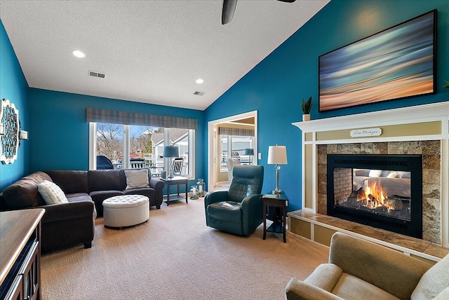 4144 Ridge Rd Unit 16, Stevensville, MI 49127 - living room with carpet, vaulted ceiling, a textured ceiling, a ceiling fan, and a tile fireplace