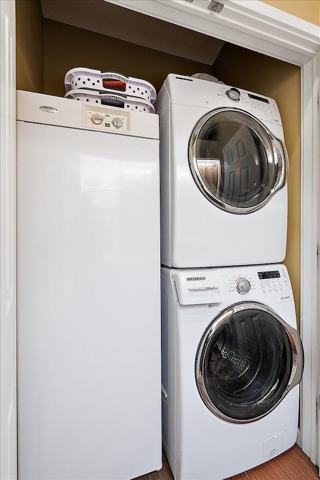 4144 Ridge Rd Unit 16, Stevensville, MI 49127 - laundry area featuring stacked washing machine and dryer and wood finished floors