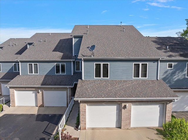 4144 Ridge Rd Unit 16, Stevensville, MI 49127 - view of front of house with driveway, an attached garage, a shingled roof, and brick siding