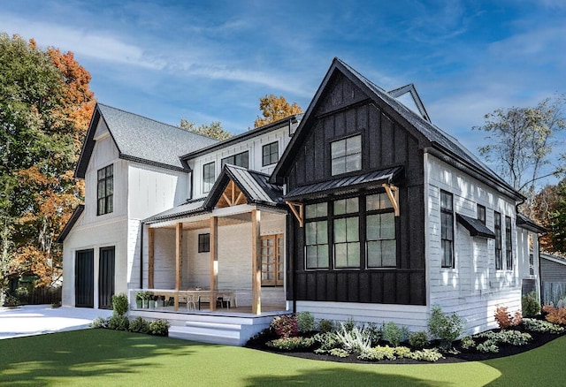 modern farmhouse style home featuring metal roof, an attached garage, concrete driveway, board and batten siding, and a standing seam roof